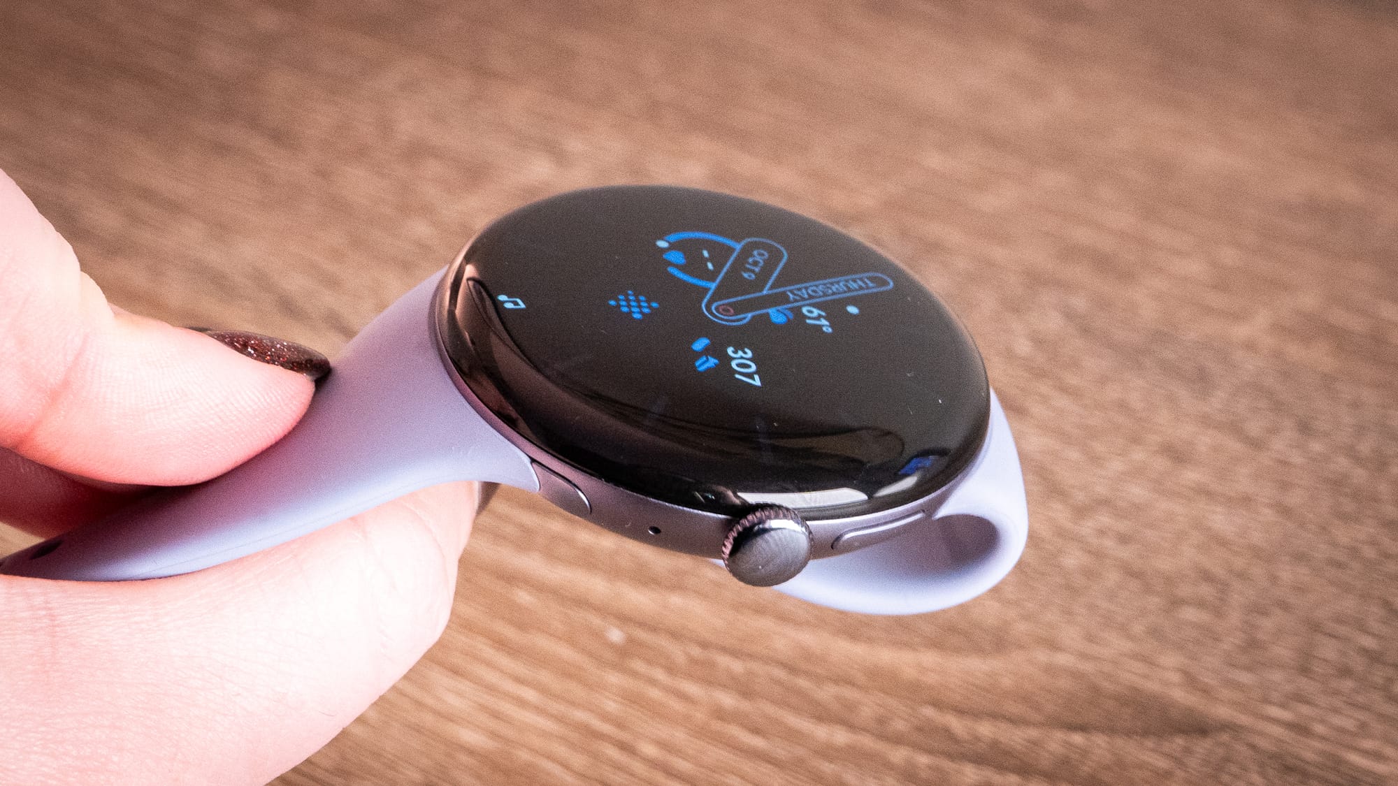 A photo of someone holding the pixel watch 4 so you can look at its side profile